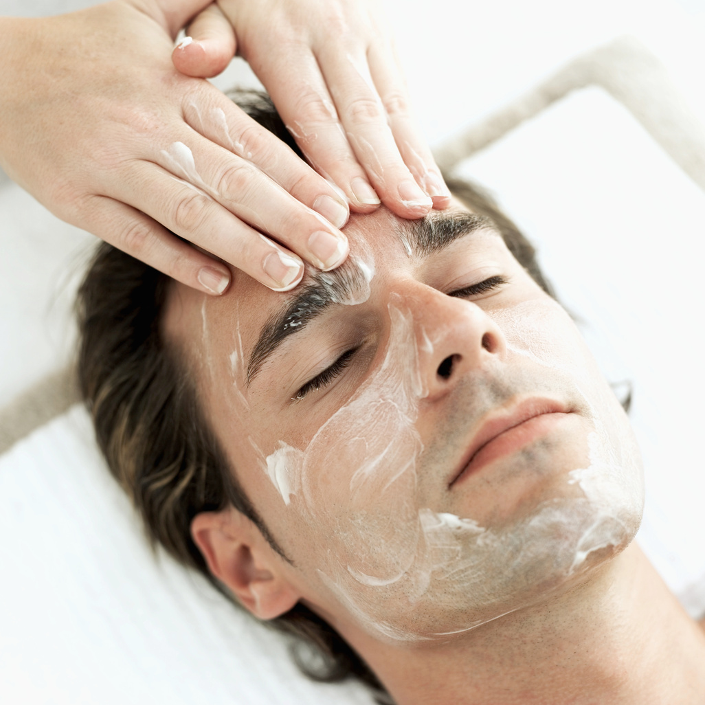 high angle view of a mid adult man getting a facial